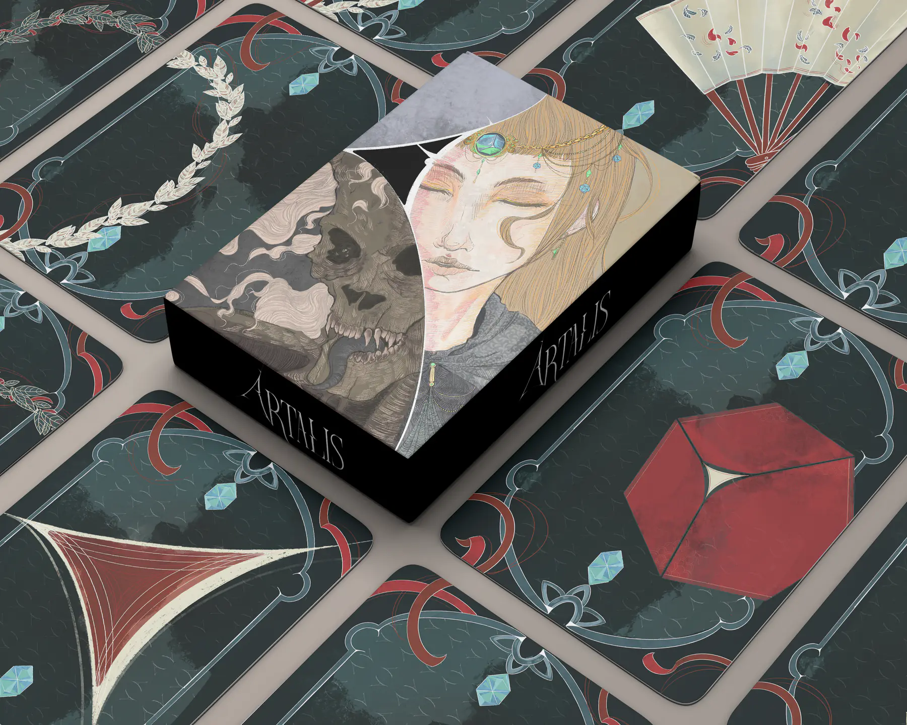 The Artalis box resting on the card backs of the four decks